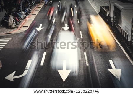 Busy city cars are passing on traffic road with the arrow sign transportation on the road