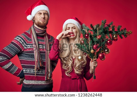 woman with a broken Christmas tree in his hand and an emotional man                     