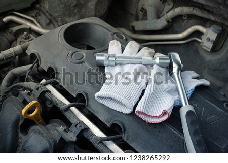 Close-up tools kit detail on auto background. Selective focus on duty dirty glove with car engine with tools