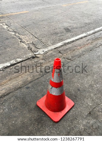 Old traffic cones standing near the road on dark asphalt