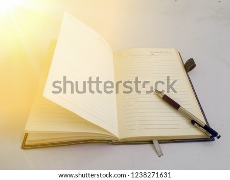 The pen is placed on a notebook. With orange edge light