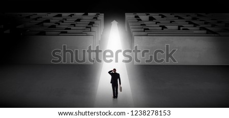 Businessman going straight ahead on a lighted carpet arrow between two maze