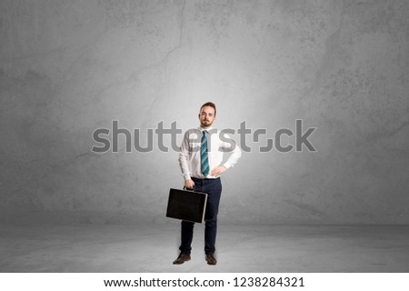 Alone handsome businessman standing in a dark empty room