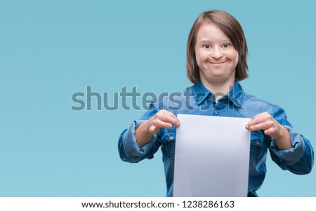 Young adult woman with down syndrome holding blank paper sheet over isolated background with a happy face standing and smiling with a confident smile showing teeth