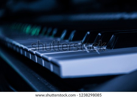 Piano keyboard background with selective focus. Cold color toned image.