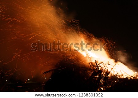 big bonfire easter celebration in dark night with flying sparks