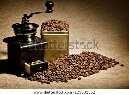 still life of the wooden old coffee-grinder stand in great plenty of coffee in  grains, close-up
