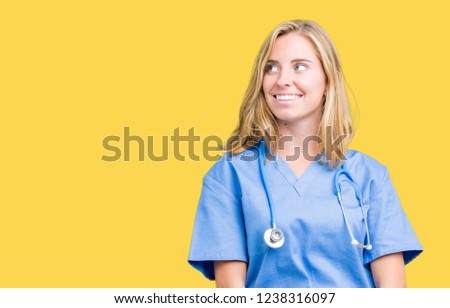 Beautiful young doctor woman wearing medical uniform over isolated background smiling looking side and staring away thinking.