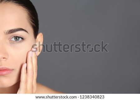 Portrait of beautiful young woman and space for text on grey background. Cosmetic surgery concept