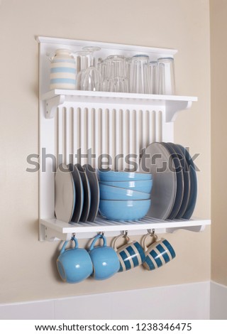 Crockery plate rack and shelves mounted on kitchen wall Royalty-Free Stock Photo #1238346475