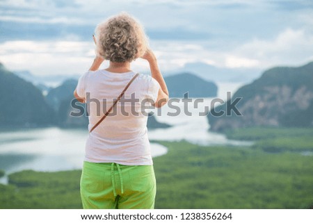 woman tourists are standing taking picture of mountain and sea views in the morning.