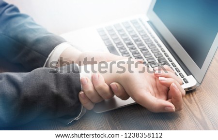 Business woman holding hands while using computer