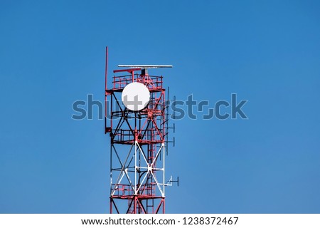 View of red and white communication tower against blue sky Royalty-Free Stock Photo #1238372467