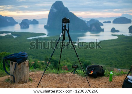tourists use a tripod. set camera to photograph the mountain and the sea.