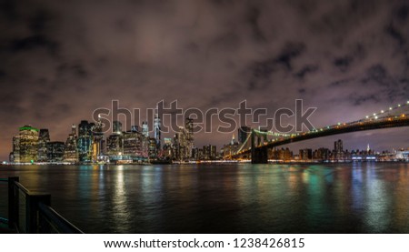 New York City Manhattan downtown panorama at night with skyscrapers illuminated over east river