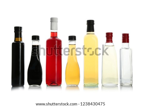 Bottles with different kinds of vinegar on white background Royalty-Free Stock Photo #1238430475