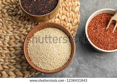 Flat lay composition with different types of quinoa on grey background