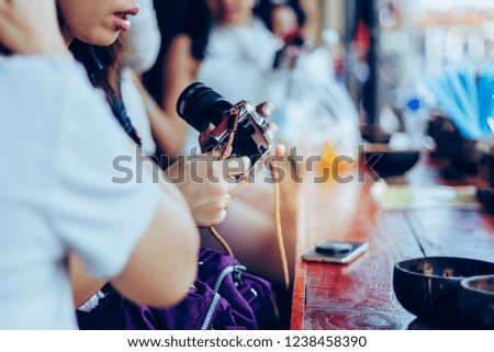 Young woman prepares a camera ready to take a photo at riverside of Amphawa, Thailand