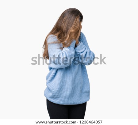 Young beautiful brunette woman wearing blue winter sweater over isolated background with sad expression covering face with hands while crying. Depression concept.