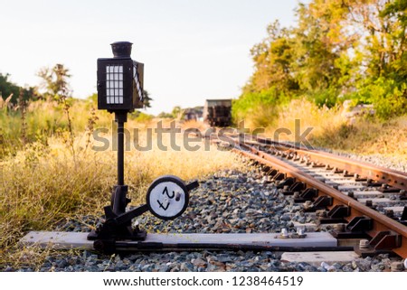 Railroad switch with train in the morning sun. The conception of  change or choices or decide. Trees and grass, yellow sunlight. Railway junction. Heavy industry. Railways.Thailand.
