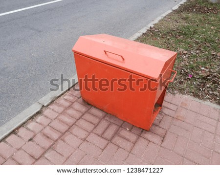 garbage box near asphalt road