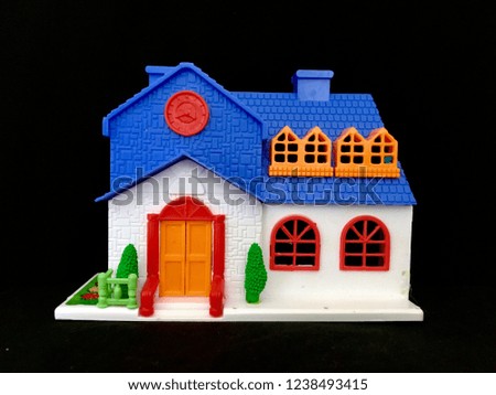 Plastic toy house on black background.