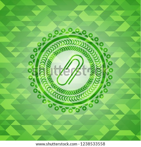 paper clip icon inside green emblem with mosaic background