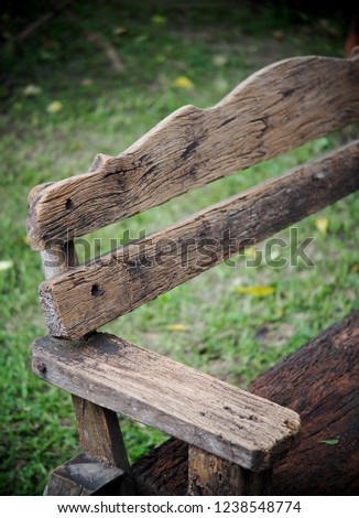 old rough grunge wooden bench seat in a park with green grass ground floor blur behind for use as picture backdrop or background