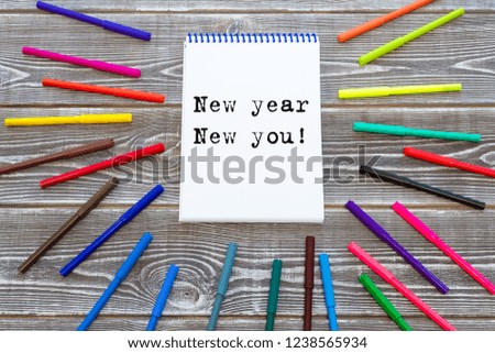 New year New you! text on a notebook surrounded by colored felt-tip pens, business concept idea, decorate paint your life, creative.