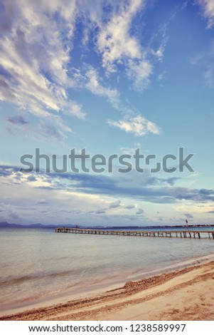 Wooden pier on the beach at sunrise, color toned picture, Mallorca, Spain.