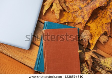 Beautiful maple leaves on vintage wooden background, border design. vintage color tone - concept of autumn leaves in fall season background and books,computer