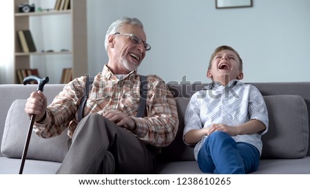 Old man and boy laughing genuinely, joking, valuable fun moments together Royalty-Free Stock Photo #1238610265