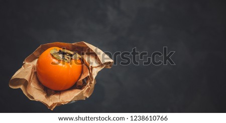 persimmon
ripe orange fruit
on a dark rustic background texture and copy space