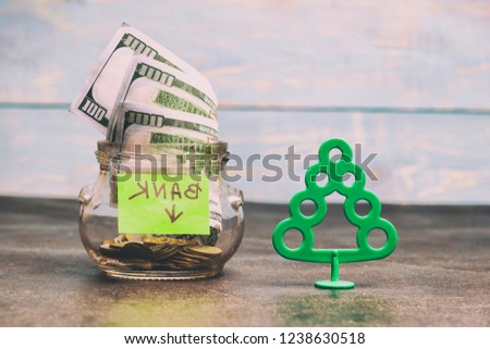Money concept, transparent glass with dollar banknote on a wooden table. tree is a profit symbol, there is toning. shallow depth of cut.
