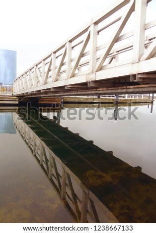 Water level view of metal bridge crossing over water at Friends of Lakeshore State Park in Milwaukee in Wisconsin