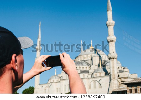 Tourist photographs the Blue Mosque in Istanbul in Turkey for memory.