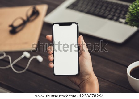 Woman with headphones using blank mobile phone with music application, copy space