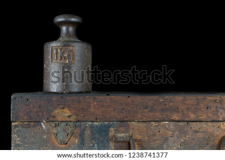 A kilogram weight used for weighing a given quantity in the store. Weights of one kilogram and two kilograms. Dark background. Royalty-Free Stock Photo #1238741377