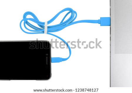 close-up blue usb cable connect phone and laptop computer new technology concept