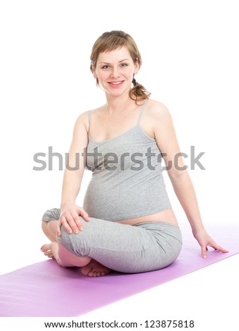 Pregnant woman doing gymnastic exercises isolated  on white