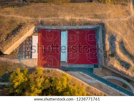 Drone photo of basketball courts among the trenches of the forest at autumn