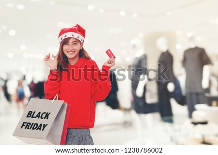 Woman Holding Shopping Bag and Credit Card on  Shopping Mall Background. Black Friday Sale