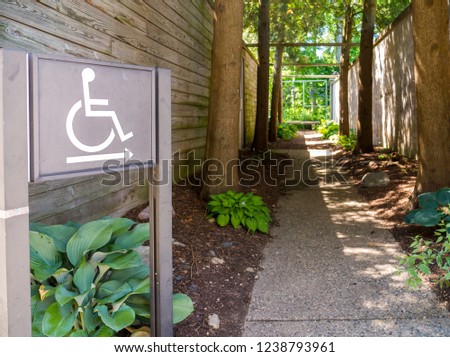 ADA Compliant Handicap disability signs with symbol in park for accessibility and compliance