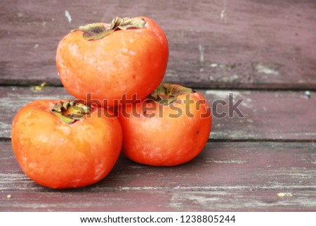 Ripe of orange persimmon fruit and on wooden background.Persimmon have a lot of fiber,low calories and fat good for dieting.Flat lay.