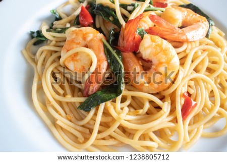 Shrimp spicy spaghetti thai style with herb on white dish close up picture.