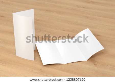 Blank trifold brochure A4 booklet on wooden background with clipping path. Folded and unfolded. 3D illustration