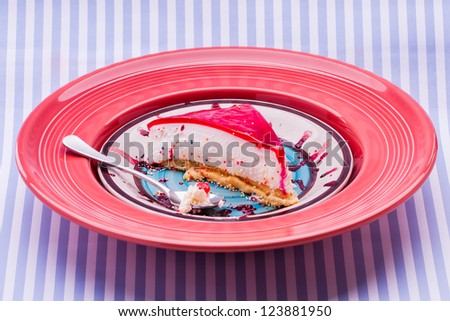 A colourful picture with cram and jello tart on a plate and striped backgound.