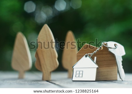 Home key with house keychain and wooden treen and home mock up on vintage wood background, property concept, copy space