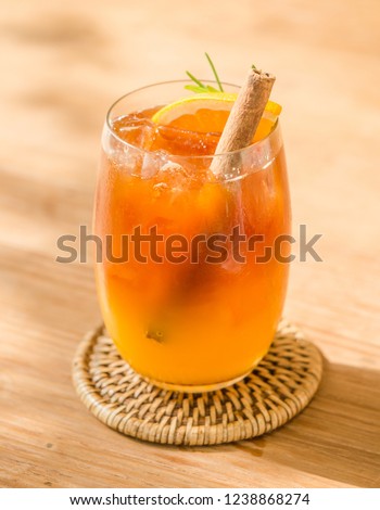 Fusion drink, coffee mix with orange juice with cinnamon in glass on table next to window. Selective focus