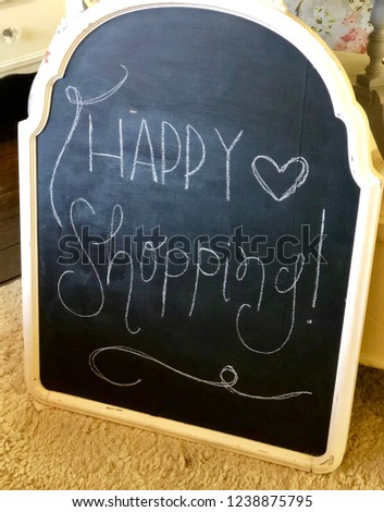Happy shopping written on black chalkboard